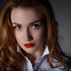 Beautiful young woman in a white man's shirt on dark background